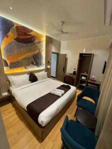 a bedroom with a large bed and a blue chair at NE Heritage Residency in Guwahati