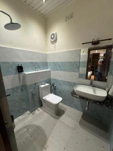 a bathroom with a sink and a toilet and a mirror at NE Heritage Residency in Guwahati