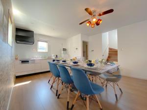 a dining room table with blue chairs and a ceiling fan at OKINAWA POOLWILLA ONNA 4A / Vacation STAY 70971 in Baba