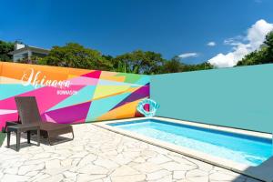 a pool with a chair next to a colorful wall at OKINAWA POOLWILLA ONNA 4A / Vacation STAY 70971 in Baba