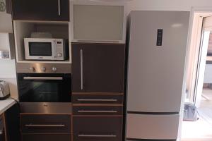 a kitchen with a refrigerator and a microwave at Peaceful house in the heart of Boutonnet in Montpellier +5 photos