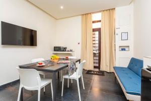 a living room with a dining room table and a blue couch at Marina Home - Luxury Apartament in Stazione Catania Porto