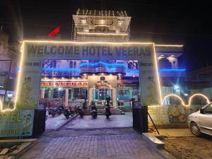 a hotel with motorcycles parked in front of it at night at Hotel Veeras in Palāi
