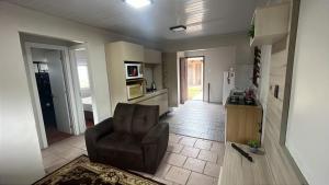 ein Wohnzimmer mit einem Stuhl und eine Küche in der Unterkunft Linda casa para suas férias ! in Imbé