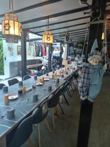 een kamer met een lange tafel met stoelen en een persoon op een schommel bij Le Val des Nymphes in Colonzelle