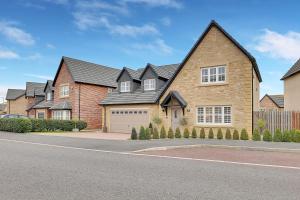 een groot bakstenen huis met een garage bij Sunrise View - North East Escapes in Long Houghton