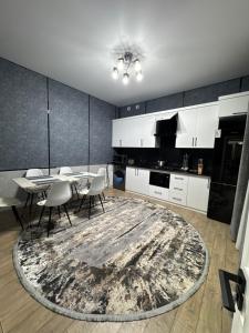 a kitchen with white cabinets and a table and chairs at Town House in Samarkand