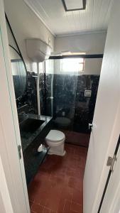ein Badezimmer mit Toilette und Waschbecken in der Unterkunft Linda casa para suas férias ! in Imbé + 6 Fotos