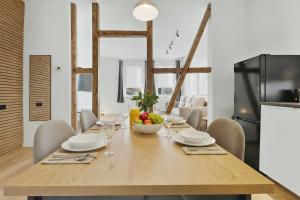 a kitchen and dining room with a wooden table and chairs at MILPAU Herne1 - Zentrales, modernes Design-Apartment - Smart TV, Nespresso für 4 Personen in Herne