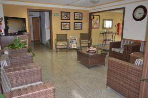 a living room with wicker furniture and a tv at Hotel Graunas in São Carlos