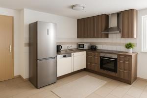 a kitchen with a stainless steel refrigerator and wooden cabinets at SUNNYHOME Ferienwohnung am Brückelsee in Wackersdorf