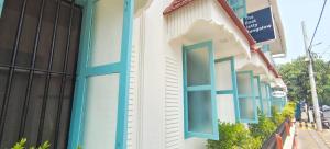 een gebouw met blauwe ramen in een straat bij The Boat Jetty Bungalow in Cochin