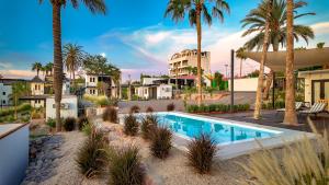 a villa with a swimming pool and palm trees at InHouse Glamping Hotel La Paz in La Paz