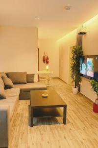 a living room with a couch and a tv at شقة 9 in Al-Safa