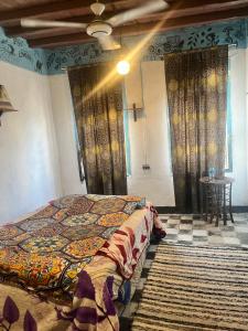 a bedroom with a bed and a table and curtains at Peacock guest house in Aswan