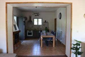 a dining room and kitchen with a table and chairs at Maison Garde Barriere in Canilhac