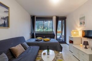 a living room with a bed and a couch at Le Cocoon de Belle Hutte sous les sapins in Xonrupt-Longemer