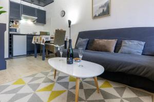 a living room with a blue couch and a white table at Le Cocoon de Belle Hutte sous les sapins in Xonrupt-Longemer