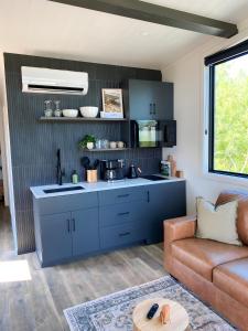 a kitchen with blue cabinets in a living room at Glamping Cabin I Best Bay Views I Near Restaurants in Gouldsboro +11 photos