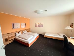 ein Hotelzimmer mit zwei Betten und einem Schreibtisch in der Unterkunft Hotel Casa Nostra in Schloß Holte-Stukenbrock