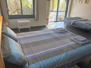 a bedroom with two beds with towels on them at Greek Relaxation in Ma‘yan Barukh