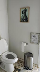 a bathroom with a toilet and a picture on the wall at Arlo's AFrame in Joshua Tree +10 photos