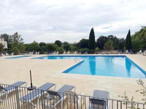 a large swimming pool with lounge chairs at Le Chant des Cigales in Azille