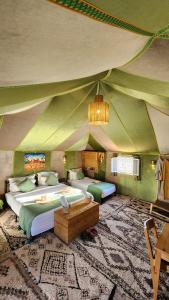 a bedroom with three beds in a tent at Unique Luxury Camp in Merzouga