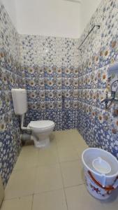 um banheiro com vaso sanitário e pia em Hotel Gokul Plaza em Bhubaneshwar