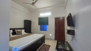 um quarto com uma cama e uma televisão em Hotel Gokul Plaza em Bhubaneshwar