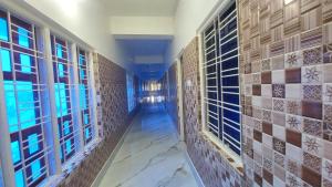 um corredor de um banheiro com paredes de azulejo e janelas em Hotel Gokul Plaza em Bhubaneshwar