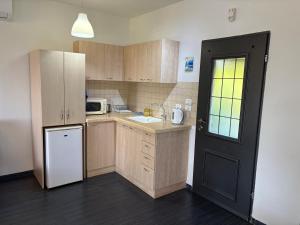 a kitchen with wooden cabinets and a white refrigerator at Greek Relaxation in Ma‘yan Barukh