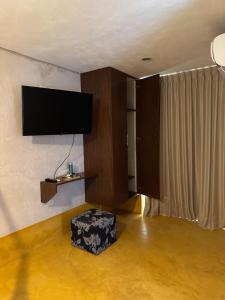 a living room with a flat screen tv on the wall at Beach Trendy Lux Villa in Chicxulub