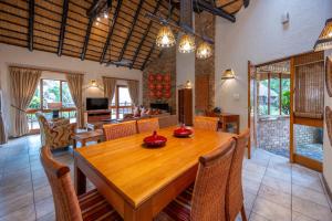 a dining room with a wooden table and chairs at Kruger Park Lodge Unit No 237 in Hazyview