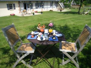 a picnic table with two children sitting at it in the grass at Manoir du Petit Saint-Pierre in Côte de Grâce