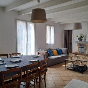 a living room with a table and a couch at Maison aux portes du centre historique de Dijon avec 3 chambres et garage in Dijon