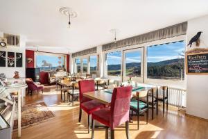 MühlenbachにあるCafé Pension Pfaus 1 fewo-4 Zimmerのテーブルと椅子、大きな窓のあるダイニングルーム