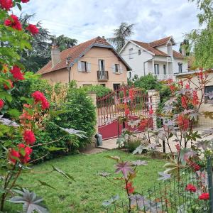 a house with a fence in a yard with flowers at Maison aux portes du centre historique de Dijon avec 3 chambres et garage in Dijon
