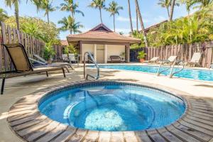 a pool with a hot tub in a backyard with palm trees at Kihei Resort 127 · KRS 127 Relaxing 1BD Condo w AC Pool Beach Ne in Kihei