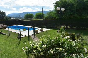 - une piscine dans une cour ornée de fleurs et de plantes dans l'établissement Aparts Solares, à San Antonio de Arredondo