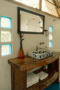 a bathroom with a sink and a mirror at Cabañas Tucan Eco Hotel in Capurganá