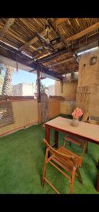 a table and a bench in a room with green grass at حياه العقر hayat alaqar in Nizwa