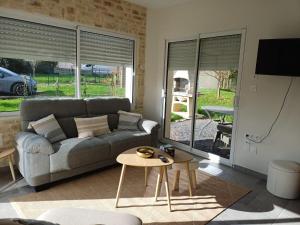 a living room with a couch and a table at Maison détente in Nonant