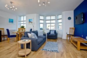 a living room with a blue couch and a table at 9 At The Beach, Torcross in Torcross