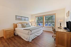 a bedroom with a bed and a desk and a television at 1 Colonial in Sunriver