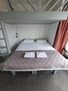 a bed in a room with two towels on it at Reef Lodge in Newquay