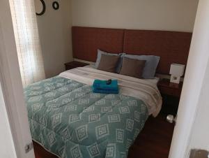 a bedroom with a bed with a blue bag on it at Departamentos Home Bulnes in Santiago