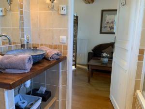 a bathroom with a sink and a living room at Manoir du Petit Saint-Pierre in Côte de Grâce +50 photos