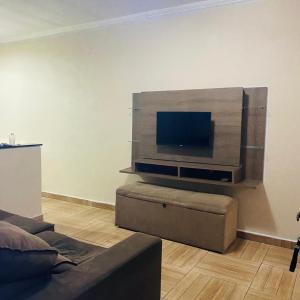 ein Wohnzimmer mit einem Flachbildfernseher an der Wand in der Unterkunft Sobrado com Piscina Oliveira in Mongaguá + 12 Fotos