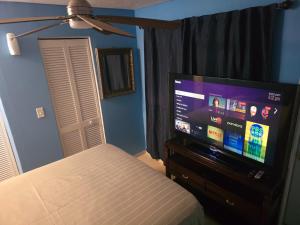 a bedroom with a bed and a flat screen tv at Healing Minds Home in Miramar